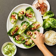 handheld fiery pork lettuce wraps on a white plate