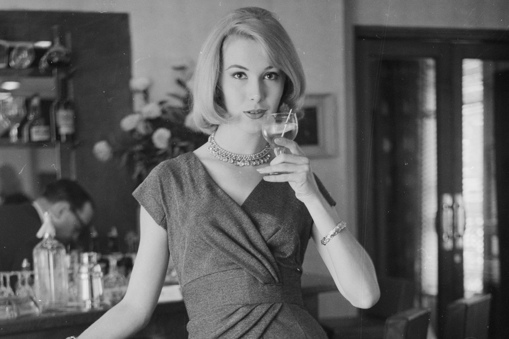 mujer elegante se bebe una copa de chardonnay 1960