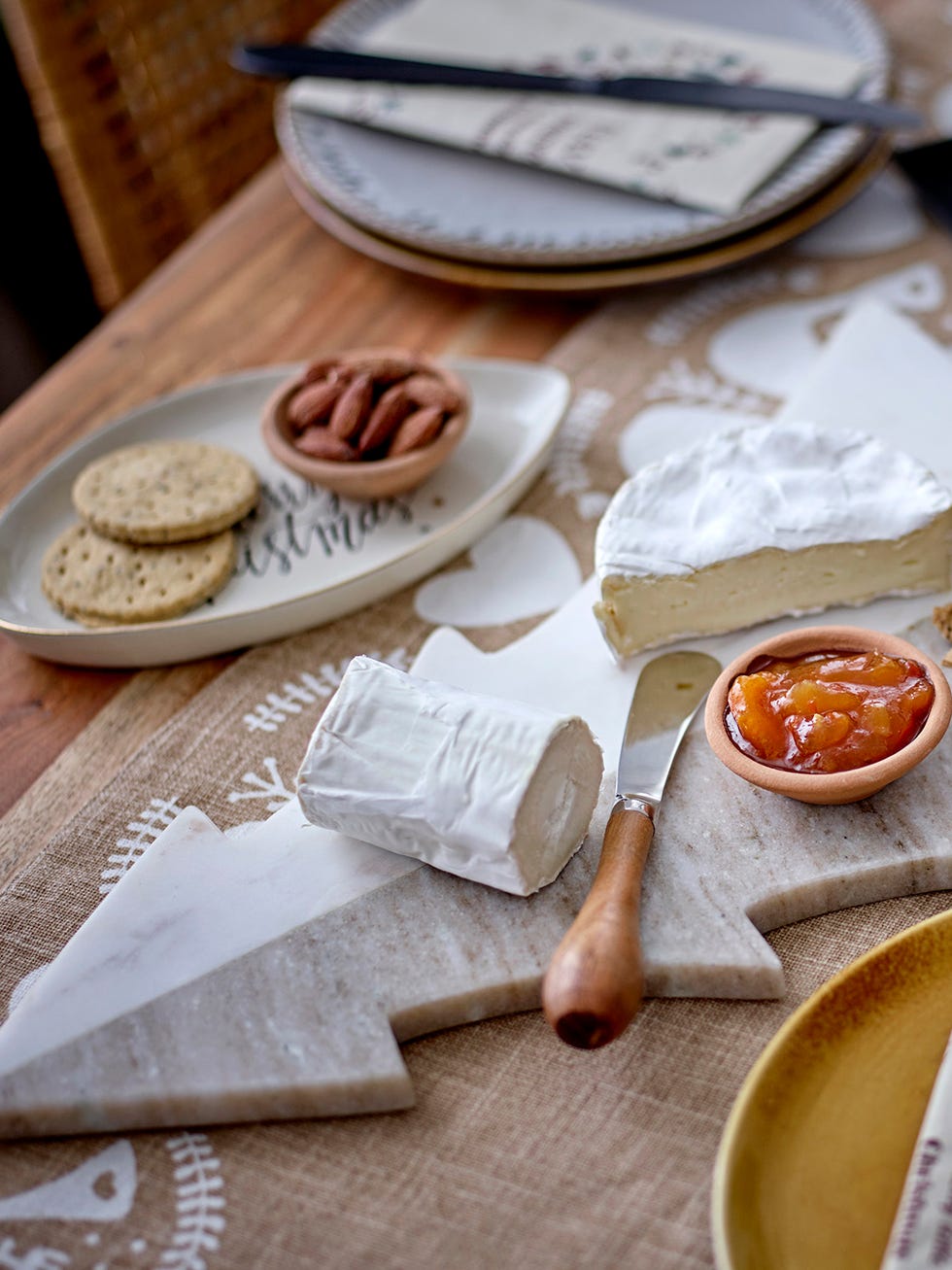 a table with details in natural fiber, wood and marble a table with food on it