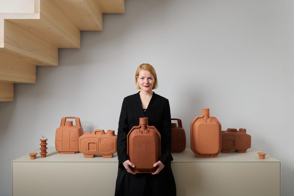 display of terracotta containers arranged with a person holding one