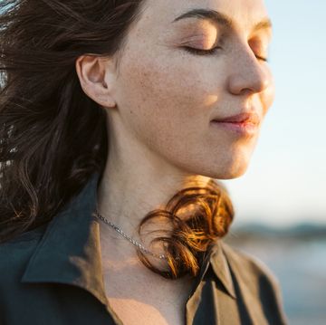 portrait of a calm woman with hair flying in the wind on the beach