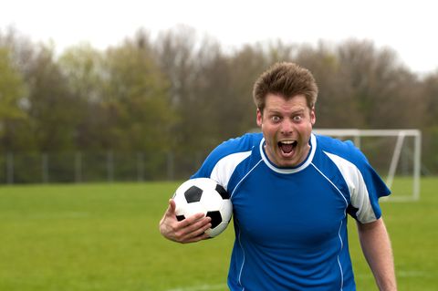 Portrait of a furious soccer player who screams at camera