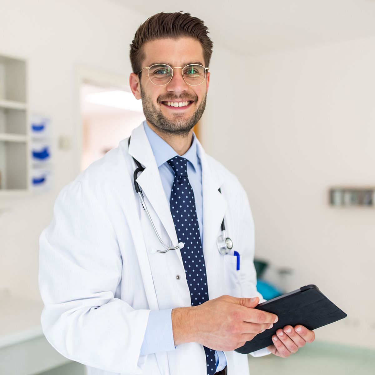 https://hips.hearstapps.com/hmg-prod/images/portrait-of-a-happy-young-doctor-in-his-clinic-royalty-free-image-1661432441.jpg?crop=0.66698xw:1xh;center,top&resize=1200:*