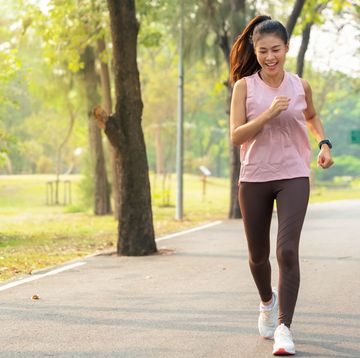 portrait of a smiling young woman having a running exercise in public park