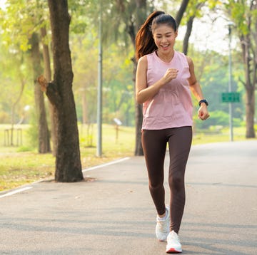 portrait of a smiling young woman having a running exercise in public park