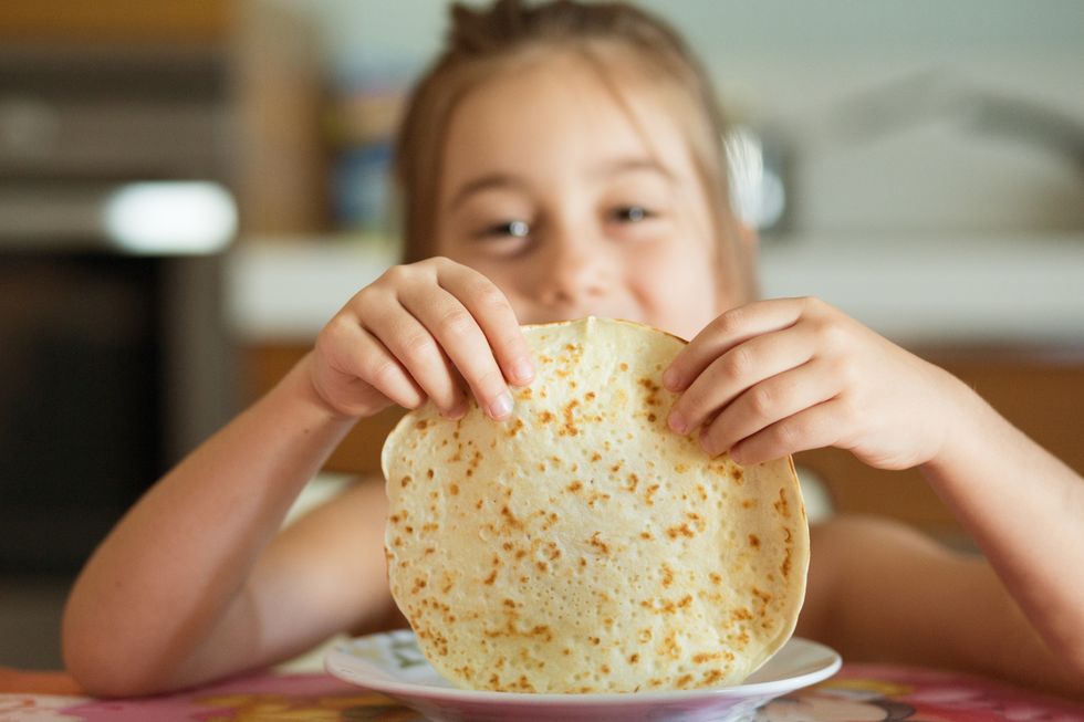 portrait of a young girl holding a pancake