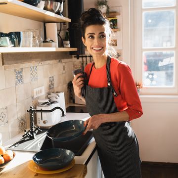 portrait of a young woman taking care of the dishes at her kitchen