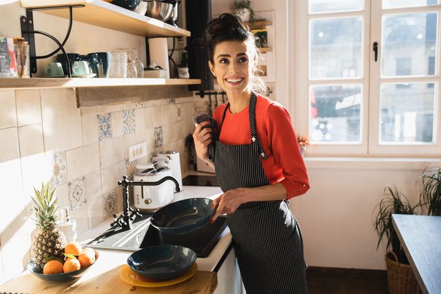 portrait of a young woman taking care of the dishes at her kitchen
