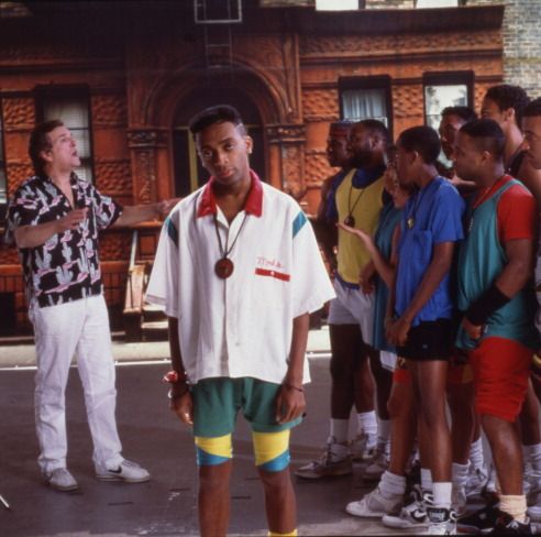 spike lee at center with danny aiello on one side and a crowd of young men to the other in a still from do the right thing