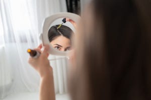 portrait of applying hair serum to her hair