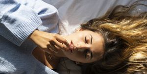 portrait of beautiful young woman lying in bed with closed eyes