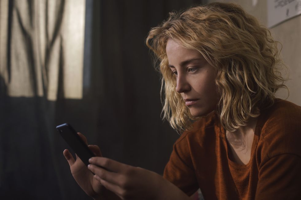 portrait of blond young woman using cell phone