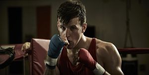 portrait of confident male boxer practicing in boxing ring at health club