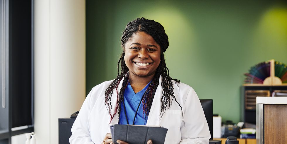 portrait of confident young doctor holding digital tablet
