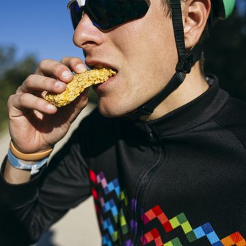 portrait of cyclist eating a snack during a break on a sunny day