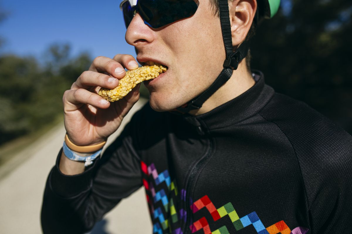 portrait of cyclist eating a snack during a break on a sunny day