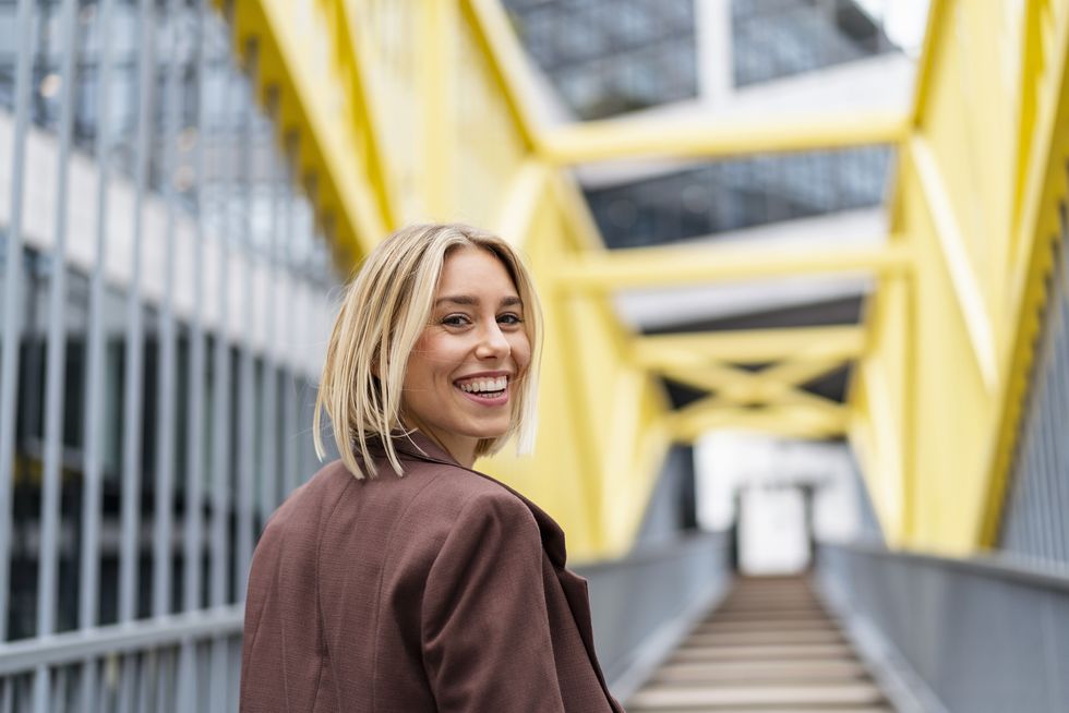 portrait of happy young businesswoman on a bridge in the city