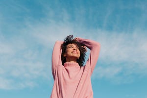 Portrait of happy young woman enjoying sunlight