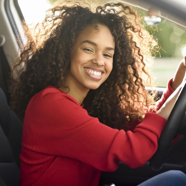 portrait of happy young woman in a car