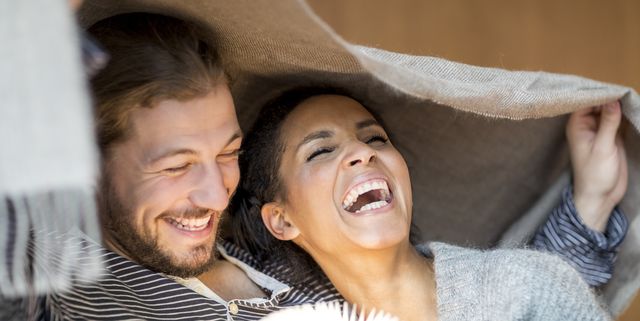 Portrait of laughing young couple at home