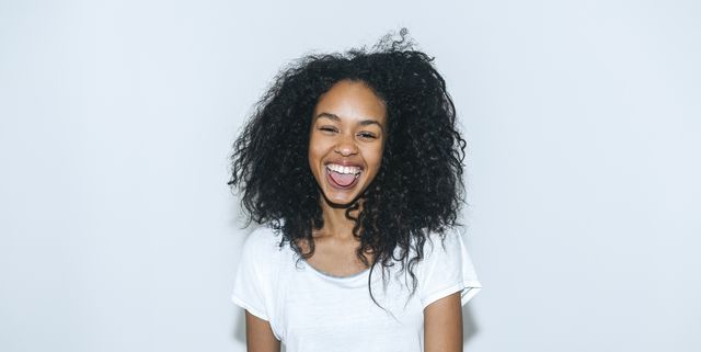 Portrait of laughing young woman sticking out tongue