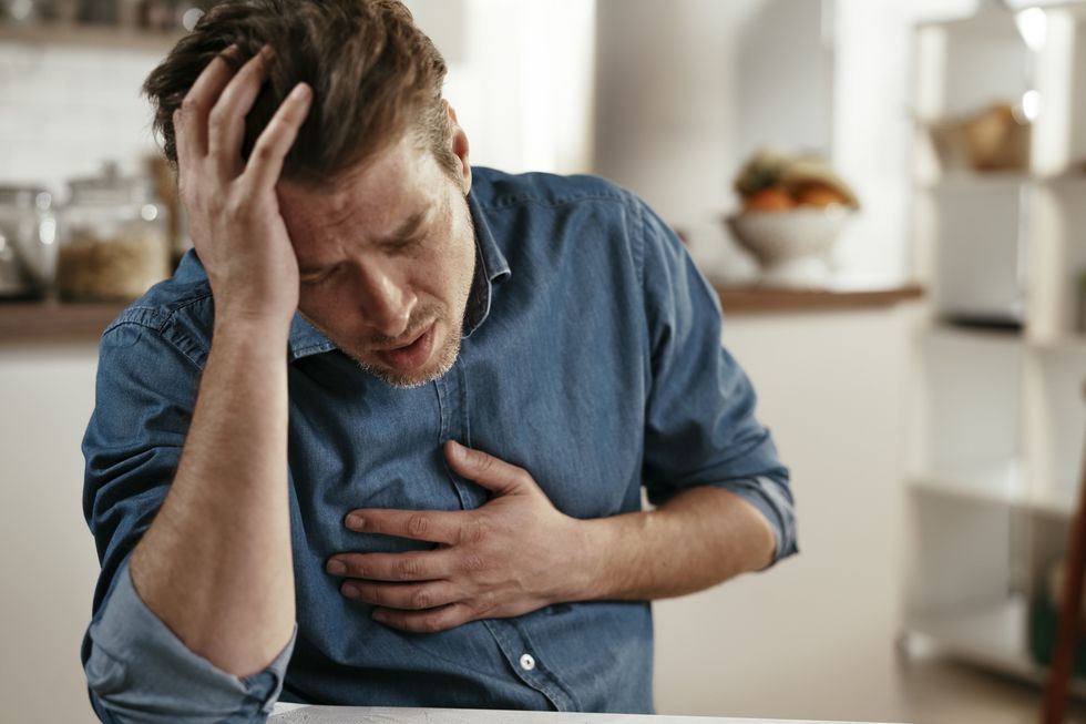 portrait of man placing hands on the chest suffering from pain in the heart