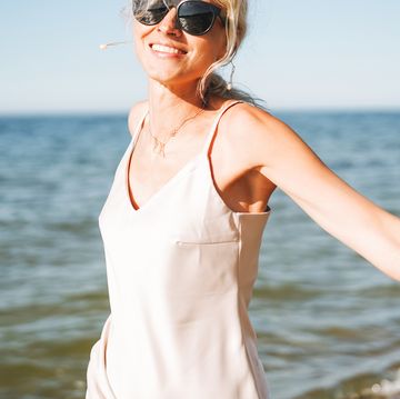 portrait of mature woman with blonde hair in silk dress enjoying life on sea beach,kaliningrad,kaliningrad oblast,russia