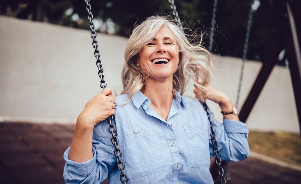 Portrait of mature woman with gray hair sitting on swing