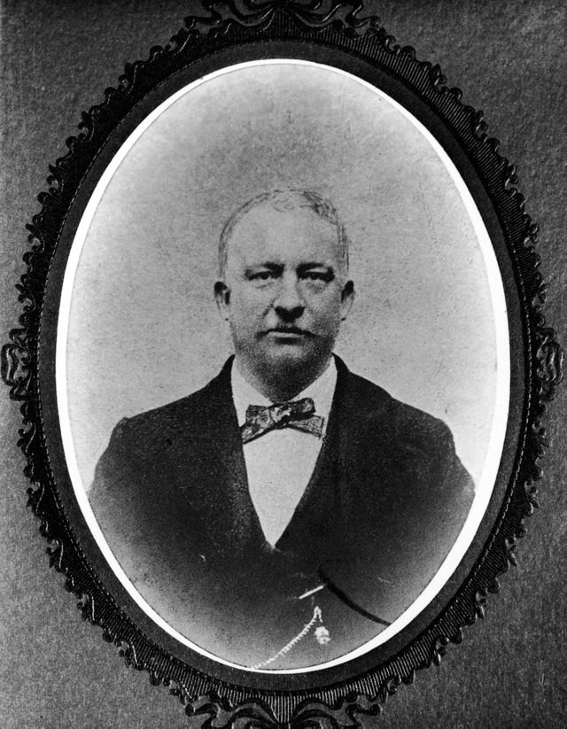 a black and white frame photo of peter mcguire wearing a suit and tie, looking directly at the camera