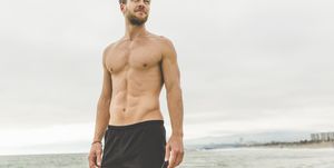 portrait of shirtless man standing on the beach