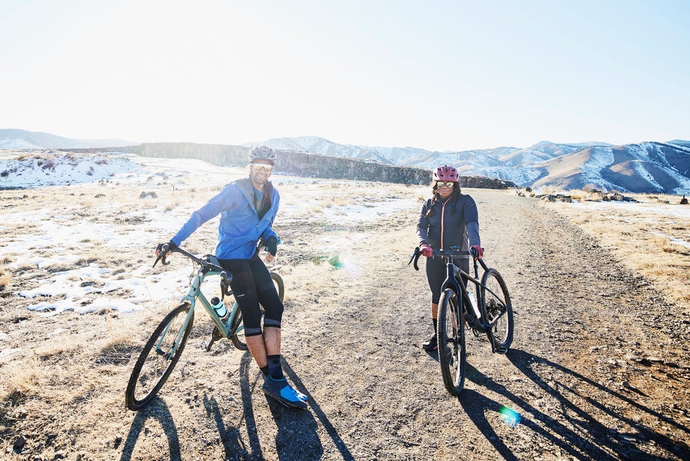 portrait of smiling friends resting during gravel bike ride on winter afternoon