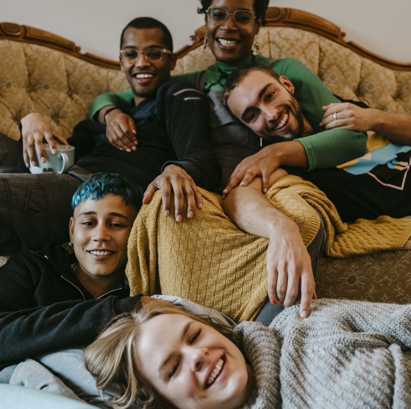 portrait of smiling male and female friends relaxing in living room
