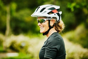 portrait of smiling mature woman relaxing after mountain bike ride with friends