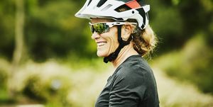 portrait of smiling mature woman relaxing after mountain bike ride with friends