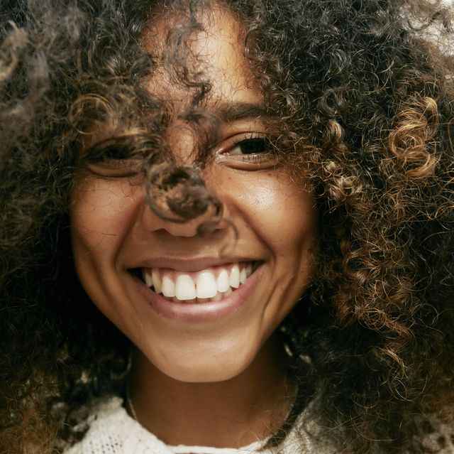 https://hips.hearstapps.com/hmg-prod/images/portrait-of-smiling-young-woman-with-brown-curly-royalty-free-image-1701209993.jpg?crop=0.668xw:1.00xh;0.183xw,0&resize=640:*