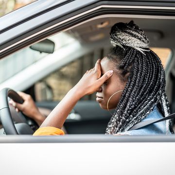 portrait of stressed african woman in car