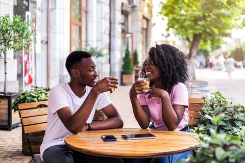 portrait of stylish black couple at summer street cafe