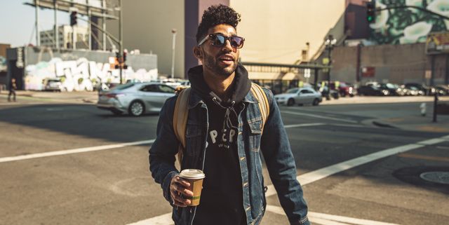 Portrait of stylish young man with coffee on the street