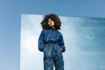 portrait of stylish young woman wearing tracksuit outdoors