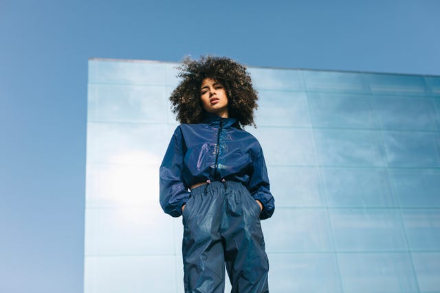 portrait of stylish young woman wearing tracksuit outdoors