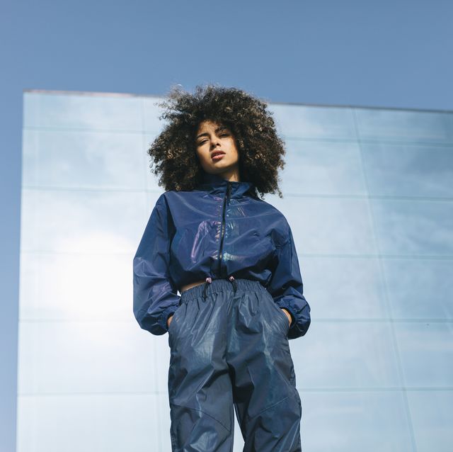 portrait of stylish young woman wearing tracksuit outdoors