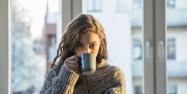 Portrait of teenage girl drinking coffee at home