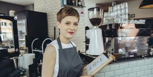 Portrait of waitress holding menu in a cafe