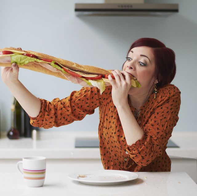 portrait of woman eating giant baguette