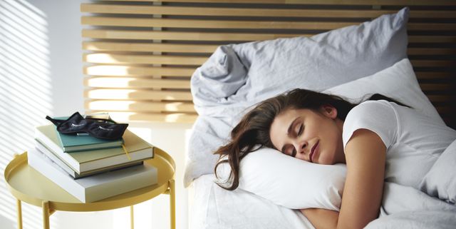 Portrait of woman sleeping in bed by daylight