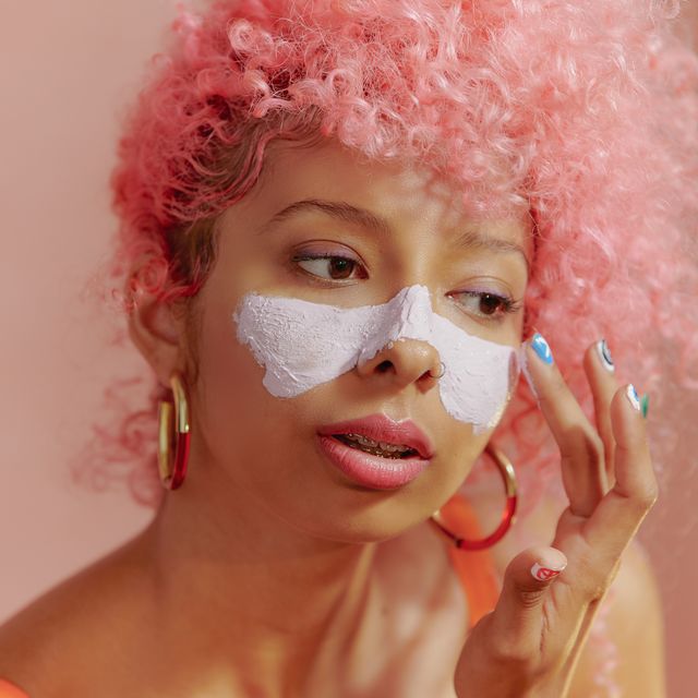 portrait of young confident women applying face mask