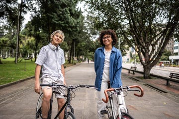 portrait of young friends mounted on the bike at public park