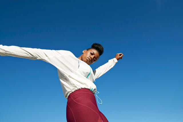 Portrait of young sportswoman against clear blue sky