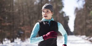 Portrait of young woman jogging in winter forest