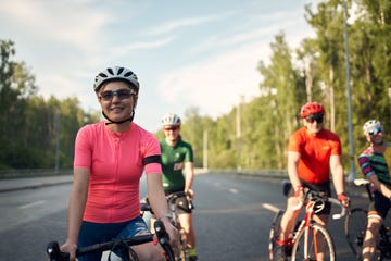 portrait of young woman with group of cyclists